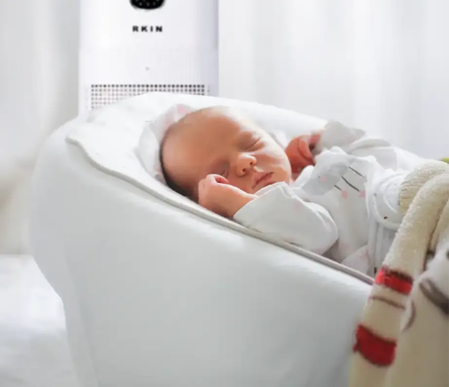 Baby sleeping in a room with an RKIN air purifier