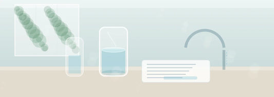 Clear glass of filtered water on a bright U.S. kitchen counter beside a water report and testing notes