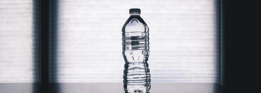 Close-up of a glass of water being poured from a countertop reverse osmosis water filter on a kitchen counter