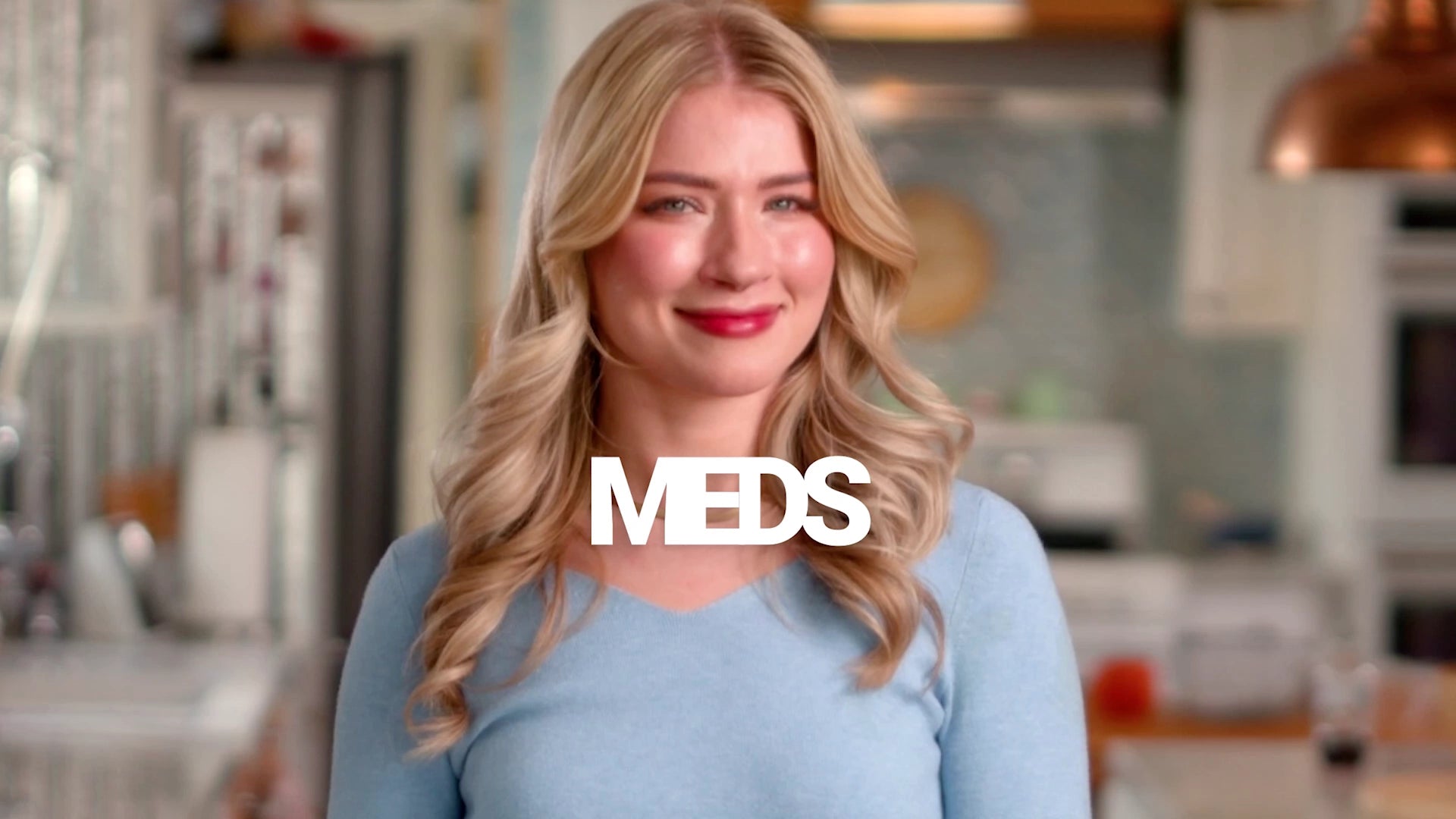 Woman in a kitchen with 'MEDS' logo overlay